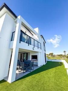 a white house with a green lawn at Grace Eleven in Stompneusbaai