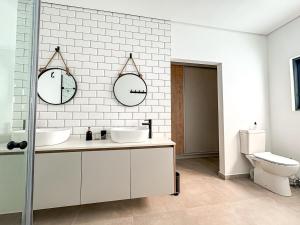 a bathroom with two sinks and two mirrors on the wall at Grace Eleven in Stompneusbaai +79 photos