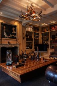 a living room with a large wooden table and a fireplace at Castle B&B Castanea in Merelbeke