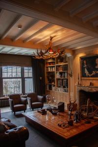 a living room with a table and a fireplace at Castle B&B Castanea in Merelbeke