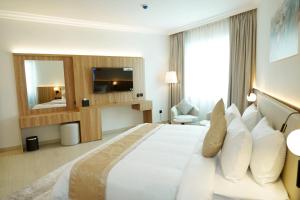 a hotel room with a large bed and a television at Al HAYAT PALACE HOTEL in Sharjah +38 photos
