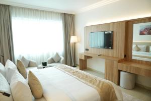 a hotel room with a bed and a tv at Al HAYAT PALACE HOTEL in Sharjah