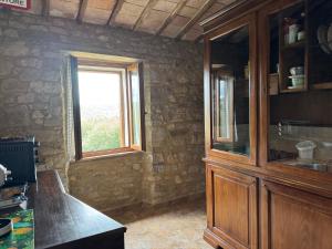 a kitchen with a wooden cabinet and a window at Guesthouse Nicol in Collelungo +2 photos