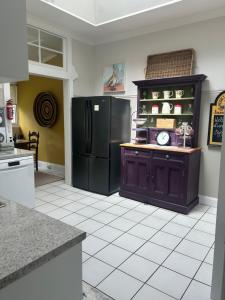 a kitchen with a black refrigerator and a tile floor at Lurline Villas in Katoomba +26 photos