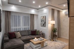 a living room with a couch and a table at Extra Apartman in Banja Luka +15 photos