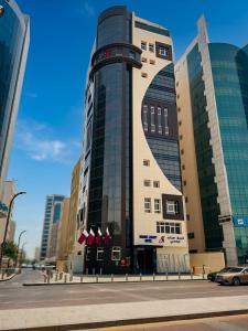 a building on a city street with buildings at Grand Legacy Hotel Doha in Doha