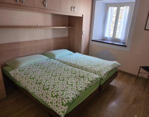 a small bed in a room with a window at Casa Ilde in Palagnedra +6 photos