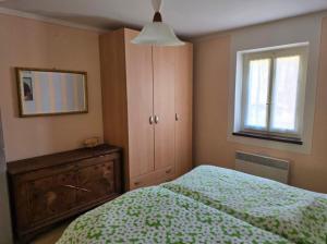 a bedroom with a bed and a cabinet and a window at Casa Ilde in Palagnedra