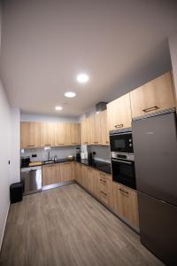 a large kitchen with wooden cabinets and stainless steel appliances at Casa Avó Libânia in Murça