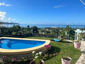 a swimming pool in a yard with a view of the ocean at Raiatea Bellevue in Uturoa