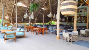 an empty restaurant with tables and chairs and lights at JAZ Amaluna - Adults Friendly 16 Years Plus in Uroa