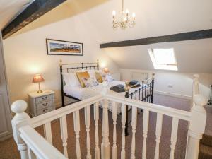 a bedroom with a bed and a stair case at Corner Cottage in Buxton