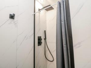 a shower with a hose in a white bathroom at Corner Cottage in Buxton +25 photos