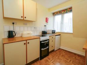 a small kitchen with a stove and a sink at Bay View in Swanage +12 photos