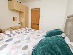 a bedroom with a bed with green pillows on it at Bay View in Swanage