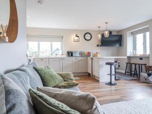 a living room with a couch and a kitchen at Hafod Y Bryn in Harlech