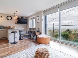 a living room with a large window and a kitchen at Hafod Y Bryn in Harlech