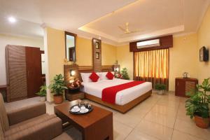 a hotel room with a bed and a living room at Hotel Indraprastha, Pattazhy in Avanīsvaram
