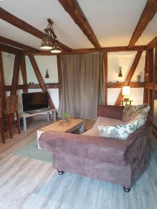 a living room with a couch and a tv at Kranichhof in Hohwacht