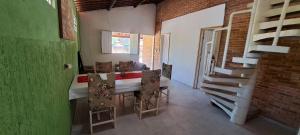a dining room with a table and a green wall at Recanto do Pontal in Japaratinga
