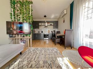 a living room with a table and a kitchen at Siera's Penthouse in Prishtinë