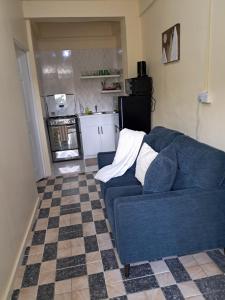 a blue couch in a living room with a kitchen at Ebenezer Comfort in Bellevue Chopin