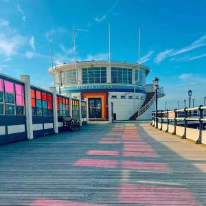 a boardwalk with a building on top of a pier at Seaview in Worthing
