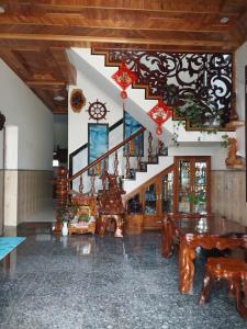 a room with a staircase and a table and chairs at Homestay Mai Trường Cù Lao Chàm in Tân Hiệp