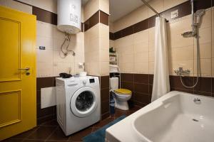 a bathroom with a washing machine and a toilet at Siera's Penthouse in Prishtinë +17 photos