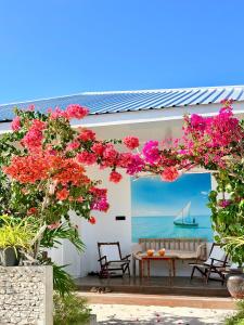 a pergola with pink flowers on a house at Crystal sea inn in Bileffahi