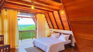 a bedroom with a bed and a balcony with a window at Cinnamon Crown in Matara