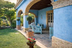 a blue house with a patio with chairs and flowers at La Masseria in Vasto