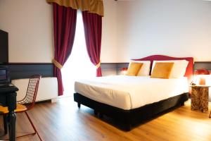 a bedroom with a large bed with red curtains at JOIVY Together Florence Secret Nest in Florence