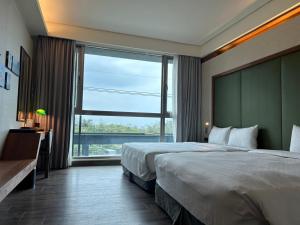 a hotel room with two beds and a large window at Taroko Liiko Hotels in Xincheng