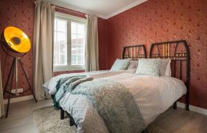 a bedroom with a bed with red walls and a window at Harmooni Suites in Jyväskylä