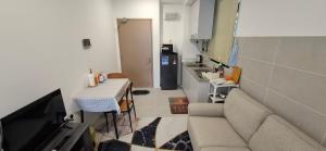 a small living room with a couch and a kitchen at D'Millenia Residences Steady in Kota Samarahan