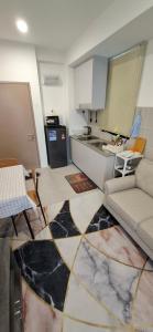 a living room with a couch and a kitchen at D'Millenia Residences Steady in Kota Samarahan