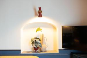 a shelf with a plant and a vase on it at JOIVY Together Florence Secret Nest in Florence
