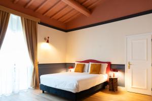 a bedroom with a bed with white sheets and gold pillows at JOIVY Together Florence Secret Nest in Florence