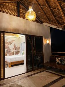 a bedroom with a bed and a chandelier at La Colonial Resort - Wellness Access Included in El Nido
