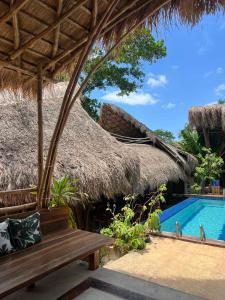 a bench in front of a resort with a swimming pool at La Colonial Resort - Wellness Access Included in El Nido