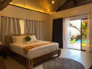 a bedroom with a bed and a large window at La Colonial Resort - Wellness Access Included in El Nido +94 photos