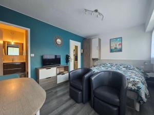 a bedroom with a bed and two chairs and a table at Studio 2 étoiles proche thermes avec parking in Aix-les-Bains