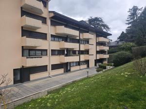 an apartment building with balconies and a green yard at Studio 2 étoiles proche thermes avec parking in Aix-les-Bains