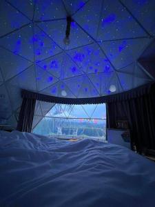 a room with a star ceiling with a bed at Phunapat camping Dome in Ban Song Phi Nong