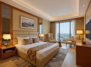 a hotel room with a bed and a desk and chairs at Hotel Grand Loft Near IGI Airport New Delhi in Pilwa