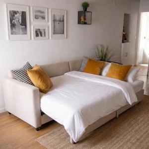 a white couch with yellow pillows in a living room at AL Belém 85 in Lisbon