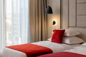 a hotel room with a bed with a red pillow at East Plaza Hotel in Sofia