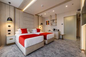 a hotel room with two beds and a bathroom at East Plaza Hotel in Sofia