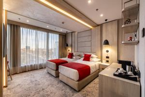 a bedroom with two beds and a television in it at East Plaza Hotel in Sofia